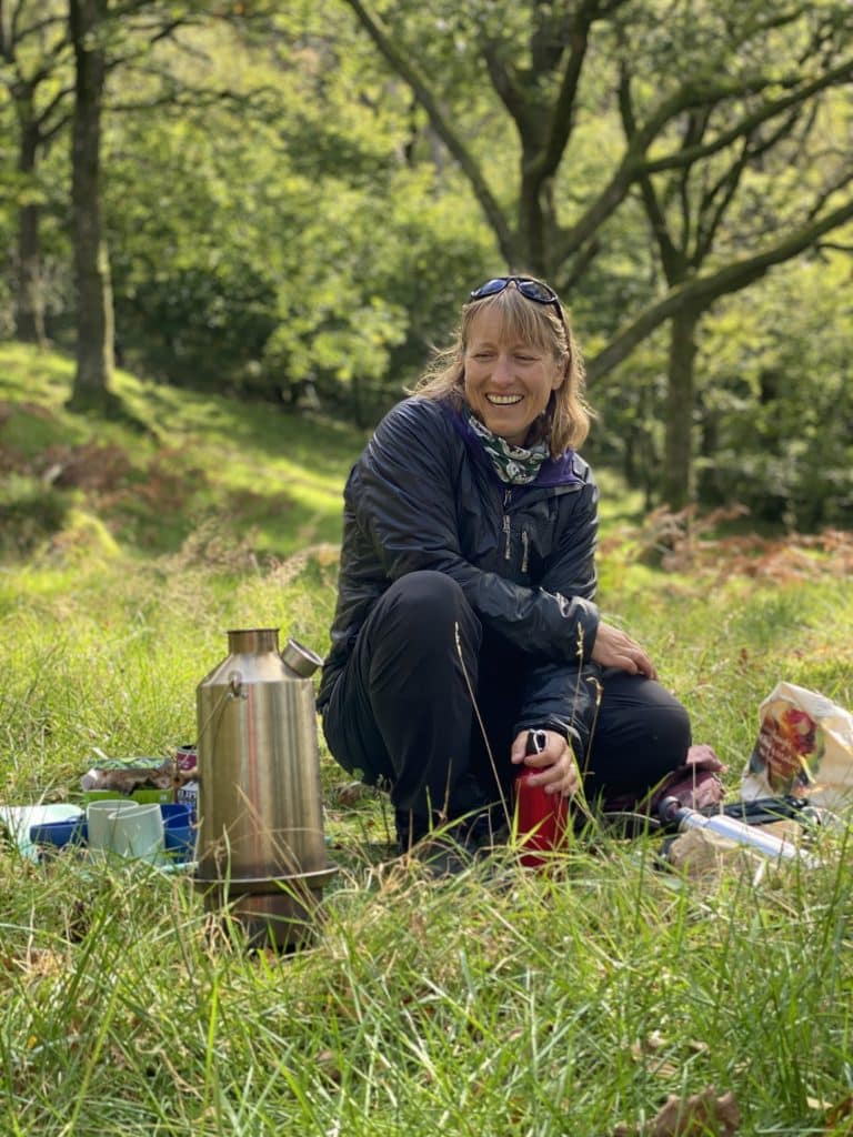 Jen Grange from Lakeland Wellbeing brewing tea during a forest bathing session in Whinlatter Forest in the Lake District.